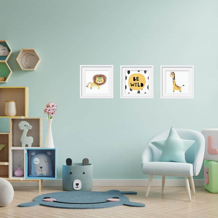 Posterset bestehend aus 3 Motiven mit einem Löwen, einer Giraffe sowie dem Spruch „Be Wild“ an einer Kinderzimmerwand.