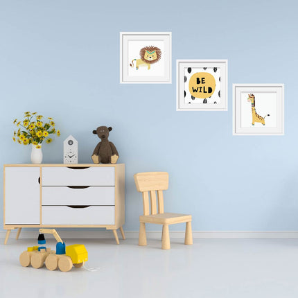 Posterset bestehend aus 3 Motiven mit einem Löwen, einer Giraffe sowie dem Spruch „Be Wild“ an einer Kinderzimmerwand.