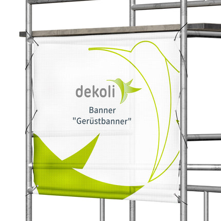 Mesh-Banner "Gerüstbanner" mit Hohlsaum oben und Unten und zusätzlichen Ösen zur befestigung. Mit grünem Dekoli Logo auf weißem Grund, montiert an einem Baugerüst für auffällige Werbung im Außenbereich
