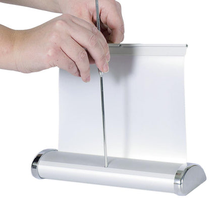 Hände montieren ein Roll-Up Banner an einem silbernen Ständer, eine einfache und schnelle Lösung für effektive Werbedisplays.