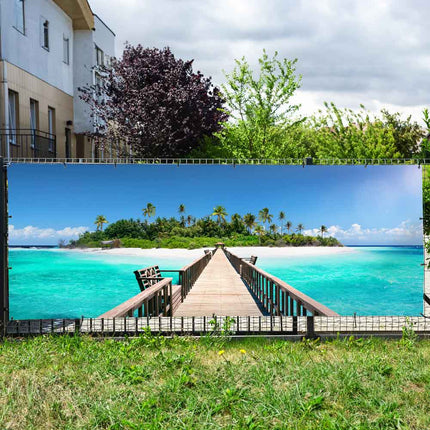 Farbintensiver Zaunbanner als Sichtschutz für Zaun und Balkongeländer mit Motiv Insel, Steg und türkisblauem Meer.
