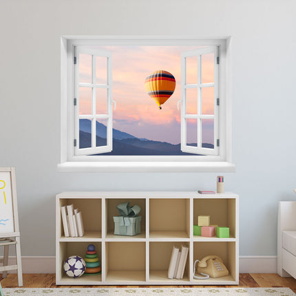 Blicken Sie auf die Schönheit der Berge bei Sonnenuntergang! Dekorativer Wandaufkleber mit gedrucktem Bild einer faszinierenden Aussicht auf eine Berglandschaft im Sonnenuntergang mit Heißluftballon, angebracht in einem Kinderzimmer über einem Regal. Die ideale Dekoration für Jung und Alt.
